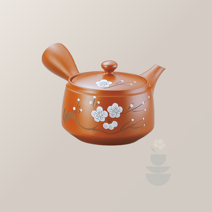 Brown ceramic teapot with floral design on a beige background
